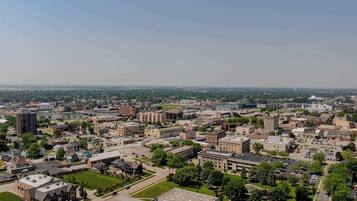 An aerial view of a university campus with multiple buildings, green spaces, and a large parking area.