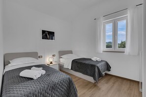 A modern hotel room with two beds, a large window, and a view of the outdoors. - Resort Moja Stina - Villa Maslina (Seoca)