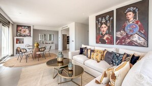 Un salon moderne comprenant un canapé, une table basse et un coin repas avec des chaises et une table.