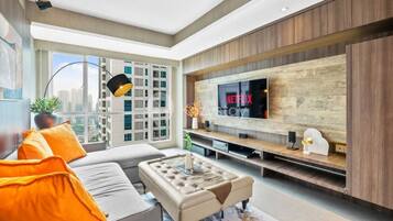 A modern living room with a large TV, a sofa, and a coffee table.