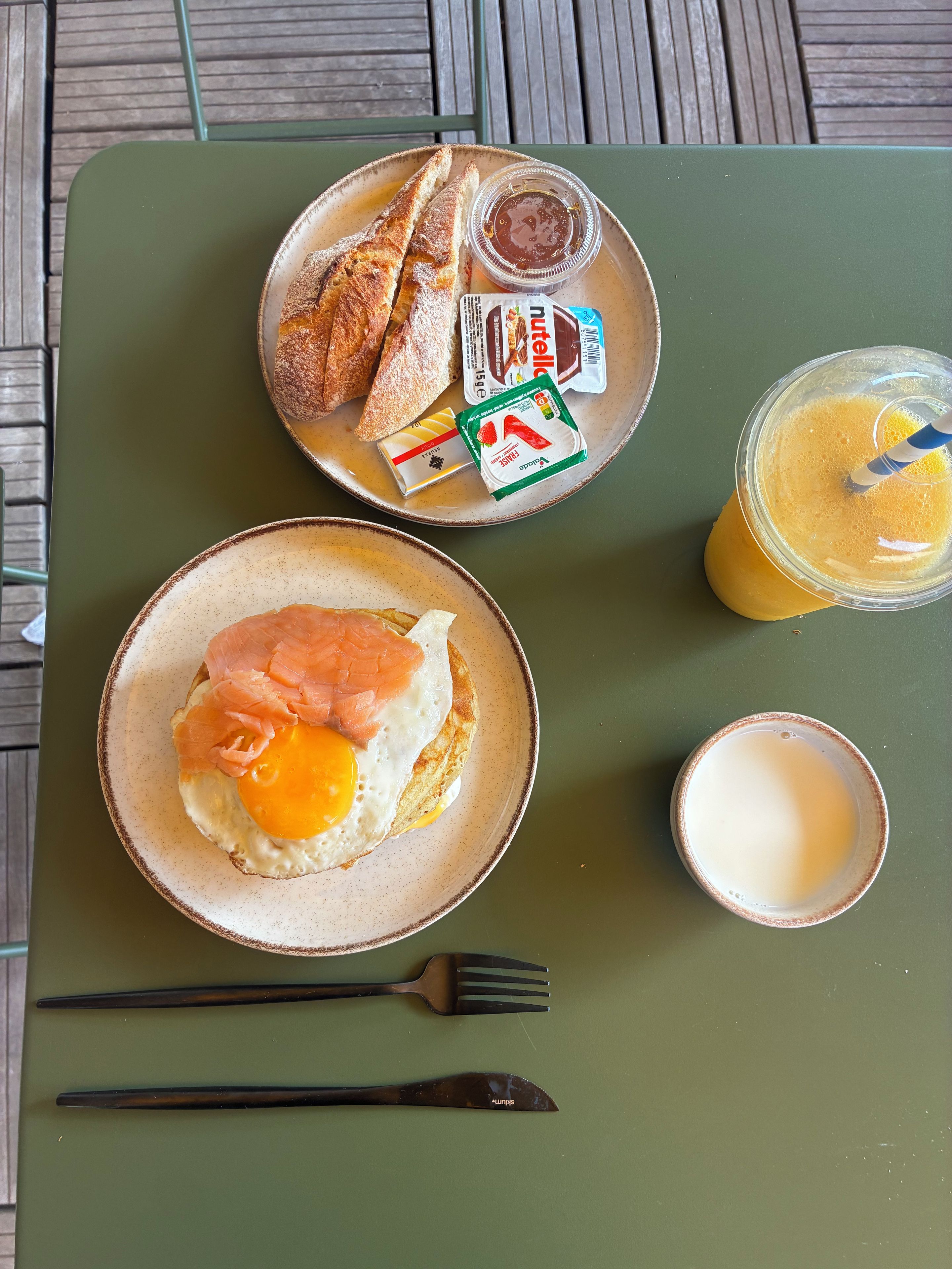 A meal with toast, salmon, and a drink on a green tray.