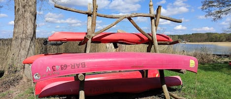 A red canoe with visible text and a wooden structure supporting it.