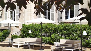 Outdoor seating with umbrellas and a building in the background.