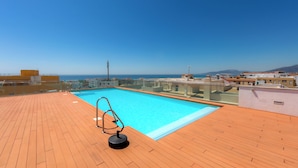 A rooftop swimming pool with a clear view of the sea and buildings in the background. - Penthouse Central: swimming pool terrace parking parking sea view (Tarifa)
