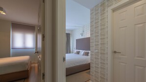 A hotel room with a bed, a bedside table, a wardrobe, and a window with curtains. - Penthouse Central: swimming pool terrace parking parking sea view (Tarifa)