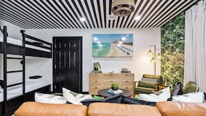 A room with bunk beds, a sofa, a coffee table, a TV, and a plant. - 30A Condo · Walk to Beach · 2 Pools + Tennis (Santa Rosa Beach)