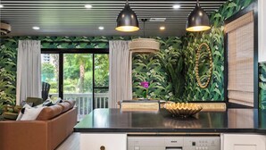 A modern kitchen with a black countertop, a Bosch dishwasher, and a decorative island with a woven centerpiece. - 30A Condo · Walk to Beach · 2 Pools + Tennis (Santa Rosa Beach)