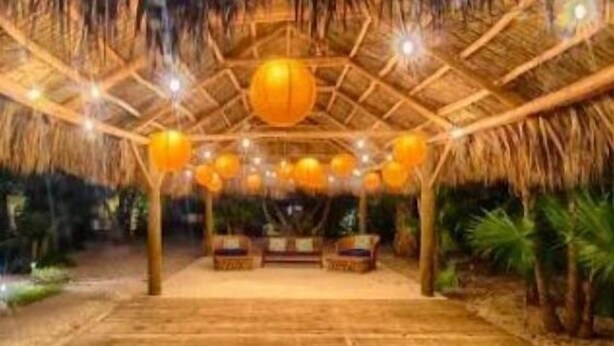 An indoor wooden structure with a thatched roof, multiple hanging spherical lights, and a central seating area. - Jacuzzi Suite Overlooking the Sea @Islamorada - Iguana Suite (Islamorada)