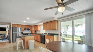 Una cocina moderna con armarios de madera, electrodomésticos de acero inoxidable y un comedor con una mesa grande y sillas.