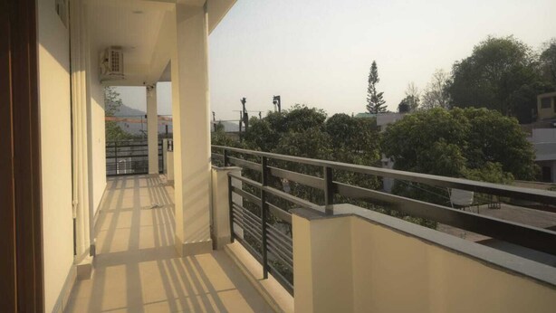 A balcony with a view of trees and buildings. - Mount Valley Mama Cottage (Rishikesh)