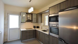 A modern kitchen with a stainless steel refrigerator, double oven, and a built-in microwave. - Villa Nopigia Mare, Kissamos Chania (Chania)