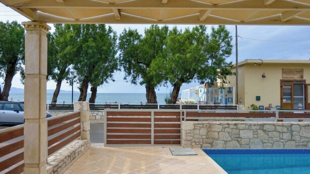 A covered outdoor area with a pool, stone walls, and wooden benches. - Villa Nopigia Mare, Kissamos Chania (Chania)