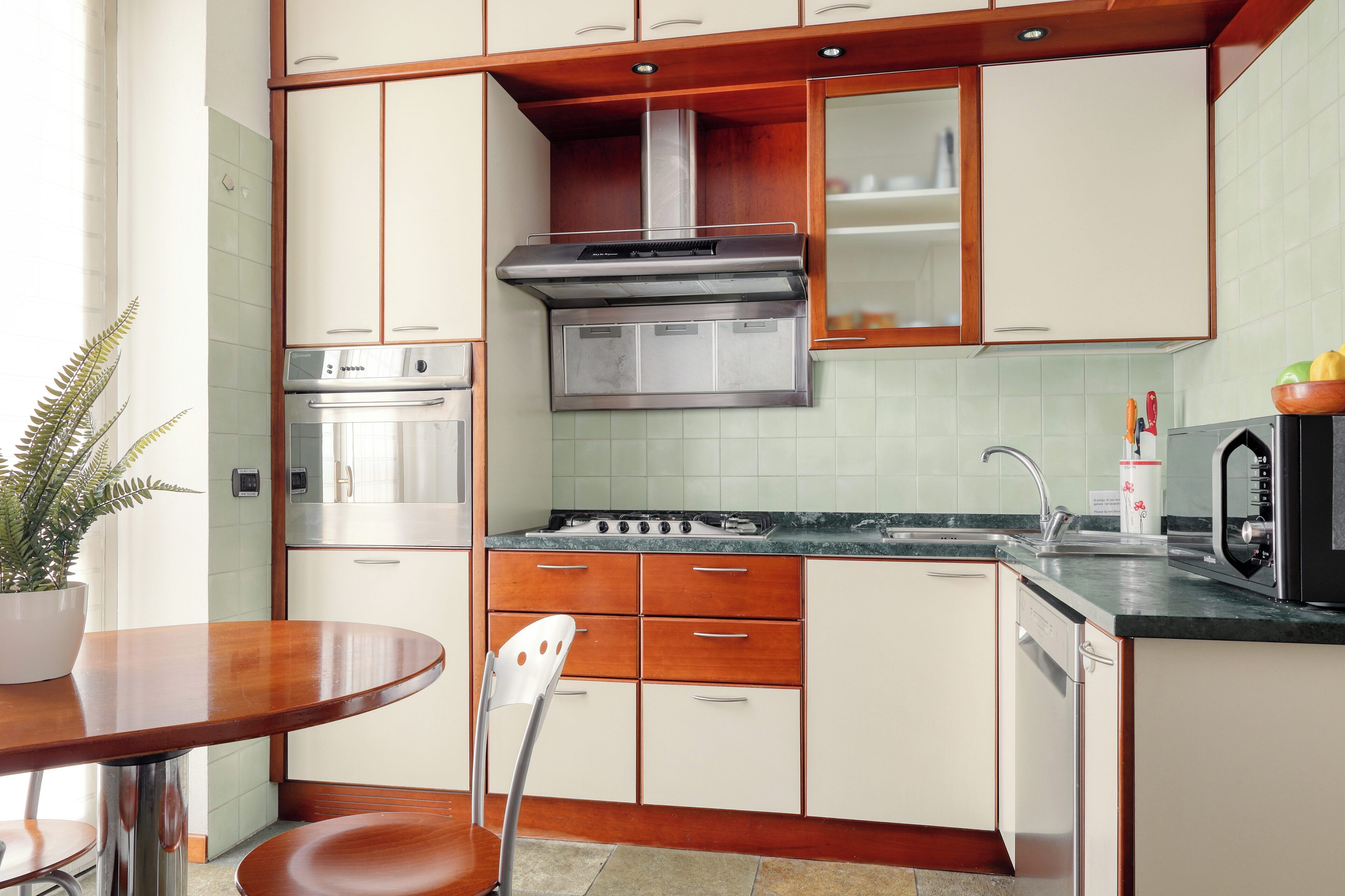 A kitchen with wooden cabinets, a stainless steel stove, and a dishwasher.