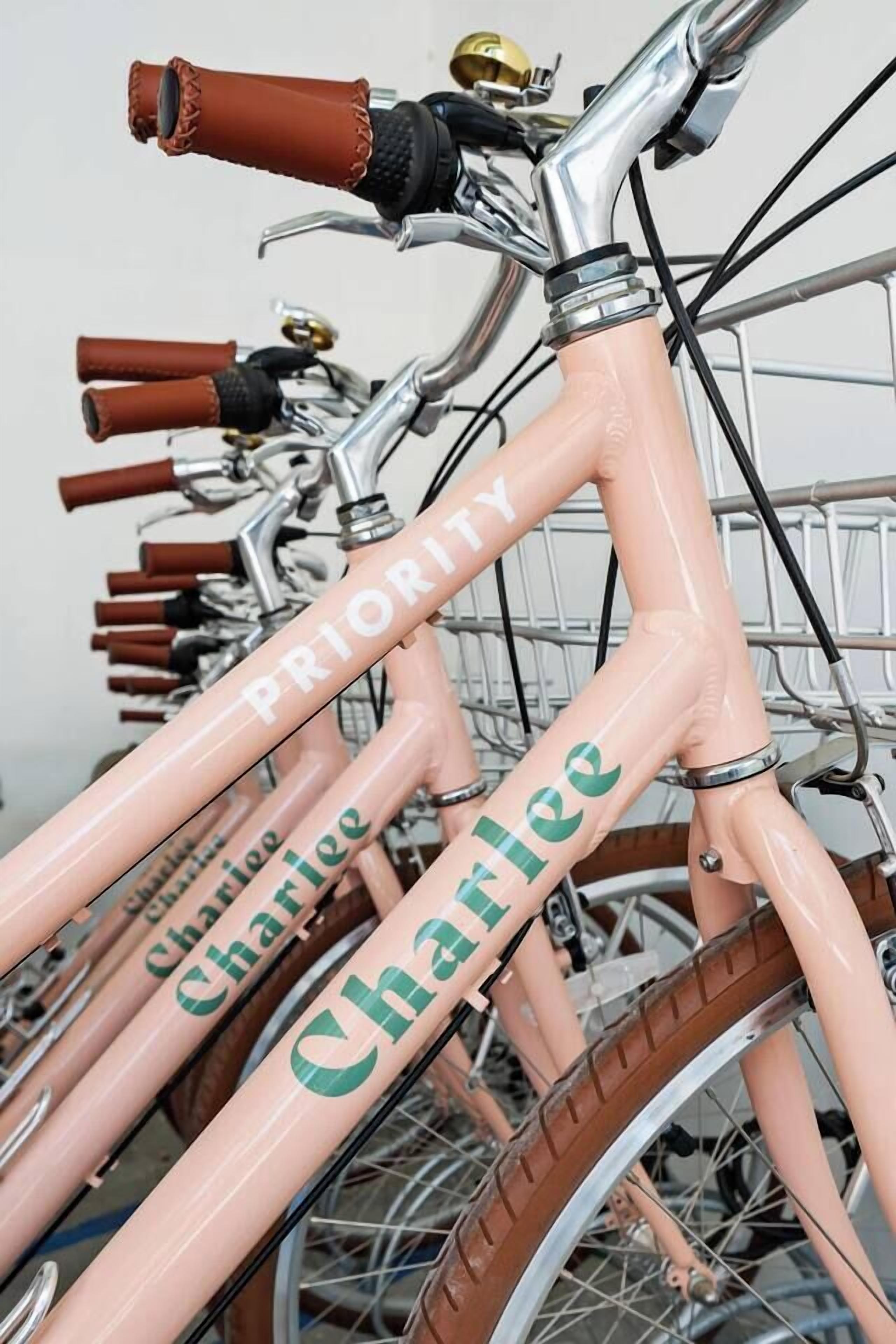Un vélo rose avec le mot « Priorité » écrit sur le cadre.