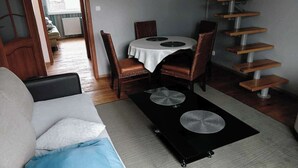 Una sala de estar con un sofá, una mesa de centro y una mesa de comedor con sillas.