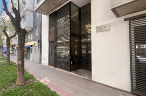 A building with a number 269 sign, a tree-lined sidewalk, and a modern architectural style.