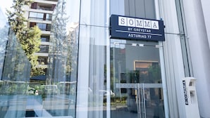 Un bâtiment moderne avec une entrée en verre et une enseigne indiquant « SOMMA BY GREYSTAR ASTURIAS 77 ».