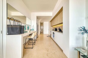 Una cocina moderna con una isla central, electrodomésticos de acero inoxidable y una pared decorativa de madera.