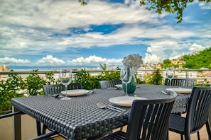 A table set for two with a view of a cityscape and greenery.