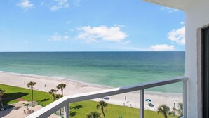 Un balcon avec vue sur une plage et l’océan.