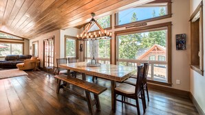 A spacious dining area with a large wooden table, benches, and chairs.