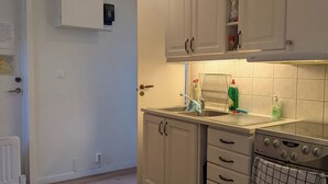Een keuken met witte kasten, een roestvrijstalen oven en een betegelde spatwand.