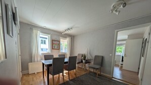 Een moderne eetruimte met een tafel, stoelen, een radiator en uitzicht op het buiten.