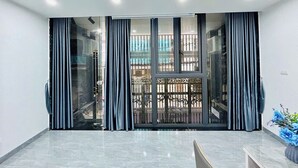 A spacious room with a large sliding glass door leading to a balcony. - Lilo's Homestay (Hanoi)