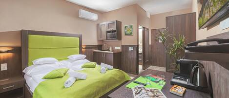 Une chambre d’hôtel équipée d’un lit, d’un bureau, d’un four à micro-ondes, d’un lavabo et d’une plante.