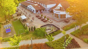 A hotel with a courtyard, outdoor seating, and a tennis court. - Park Hotel Bükfürdő (Bükfürdo)