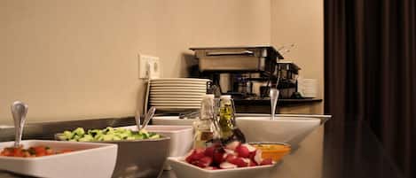 Una mesa de buffet con diversos alimentos y salsas.