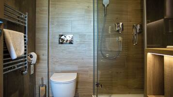 A modern bathroom with a glass-enclosed shower, a toilet, and a towel rack.