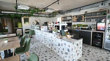 A modern bar area with a central island, seating, and a wine cooler.