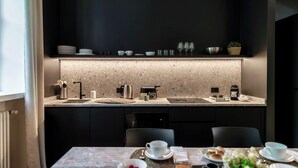Una cocina moderna con una encimera, un fregadero y un comedor con una mesa para dos.