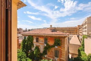 A building with a tiled roof, multiple windows, and air conditioning units.