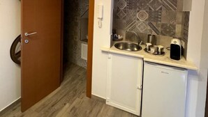 Cocina pequeña equipada con pileta, cafetera y refrigerador.