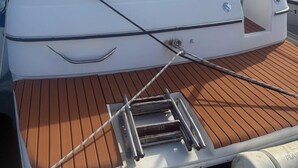 Ein Boot mit Holldeck, Steuer und Flagge.