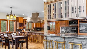 A spacious kitchen with wooden cabinets, a large island, and bar stools.