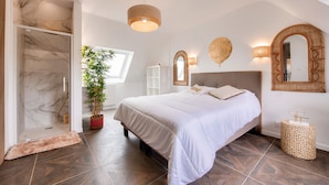 A bedroom with a large bed, a walk-in closet, a potted plant, and a shower area. - View over the Aber - House for 8 - Large garden (Lannilis)