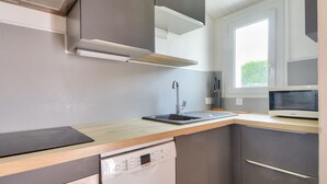 A modern kitchen with a dishwasher, sink, and microwave.