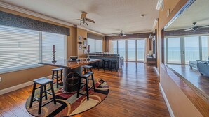 Una cocina amplia con barra, ventanas grandes y vista al océano.