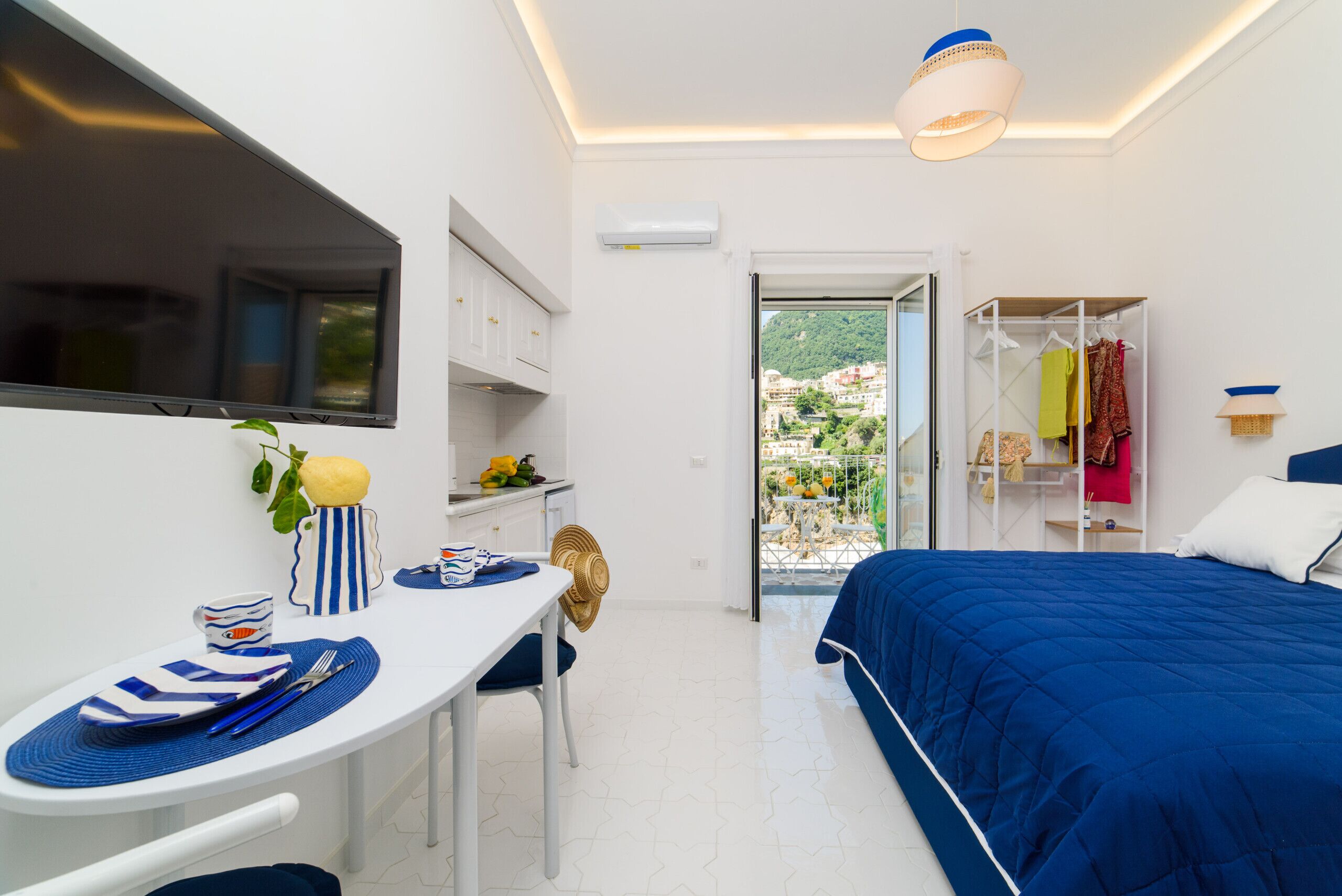 Ein modernes Schlafzimmer mit Bett, Esstisch und Blick ins Freie.