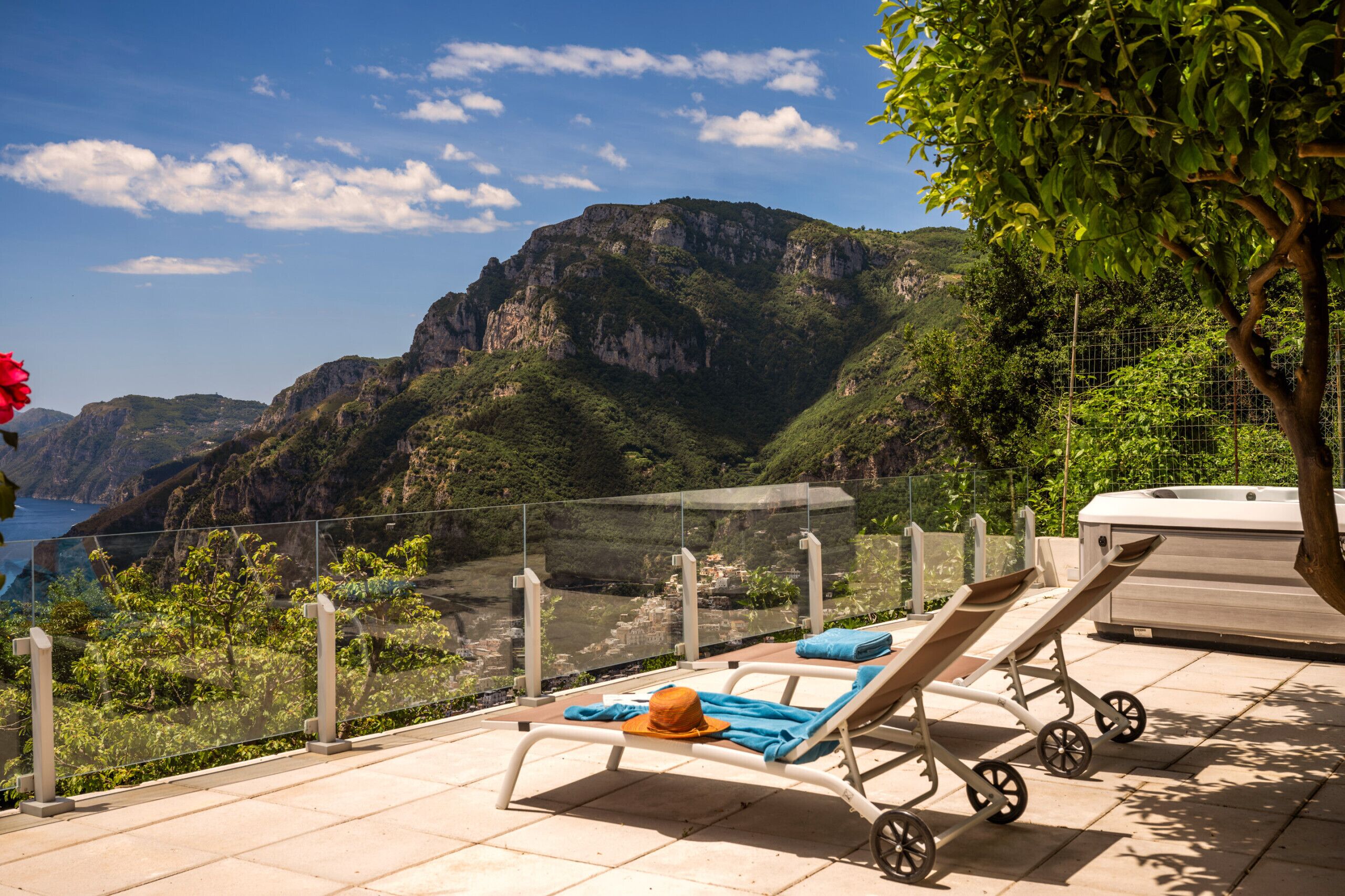 A balcony with a view of a mountainous landscape and the sea.