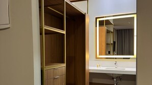 A modern bathroom with a wooden wardrobe, a vanity with a mirror, and a sink. - POUSADA BIG BEAR 2 (Campos do Jordao)