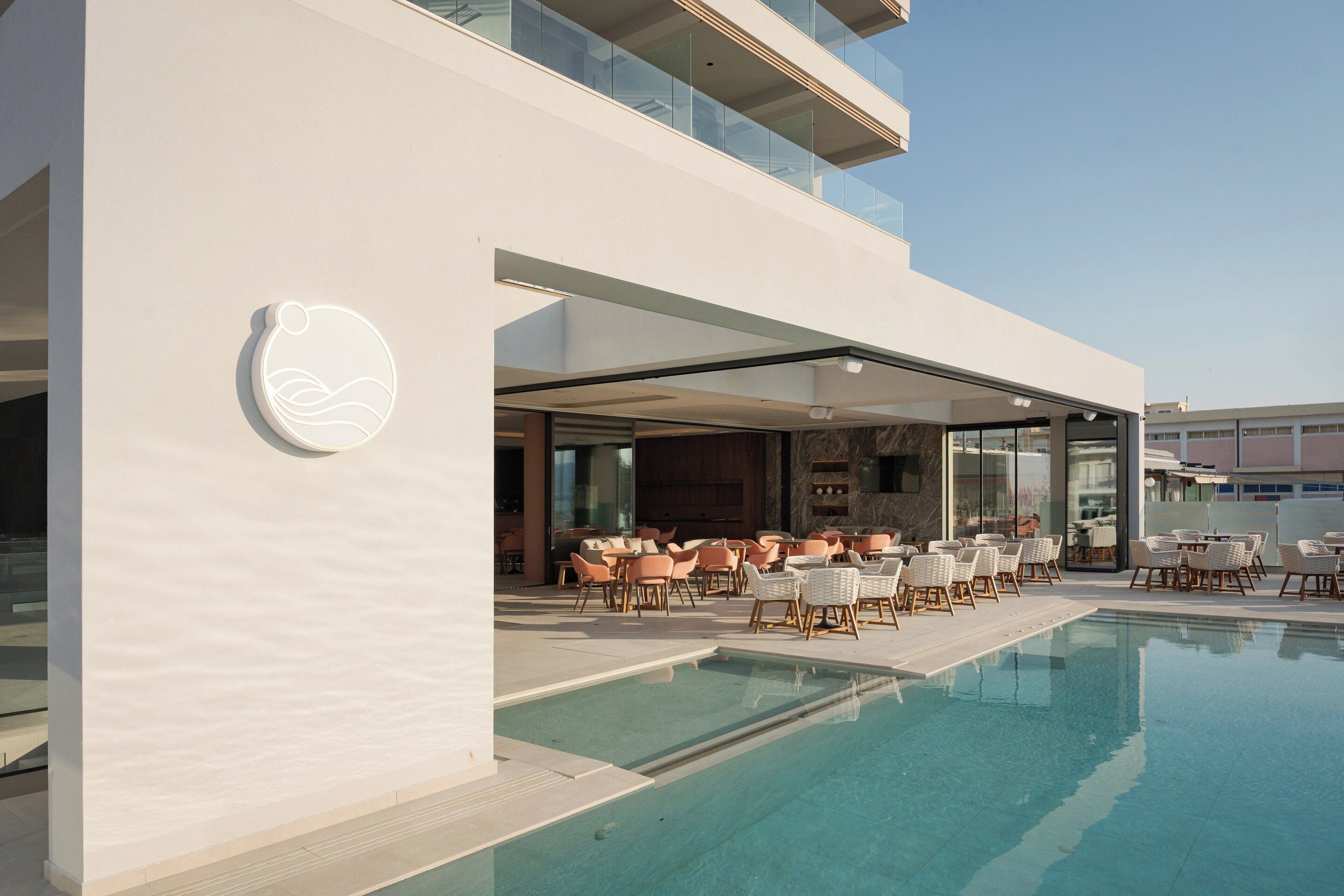 Un área de piscina moderna con sillones de descanso y vista despejada a la piscina.
