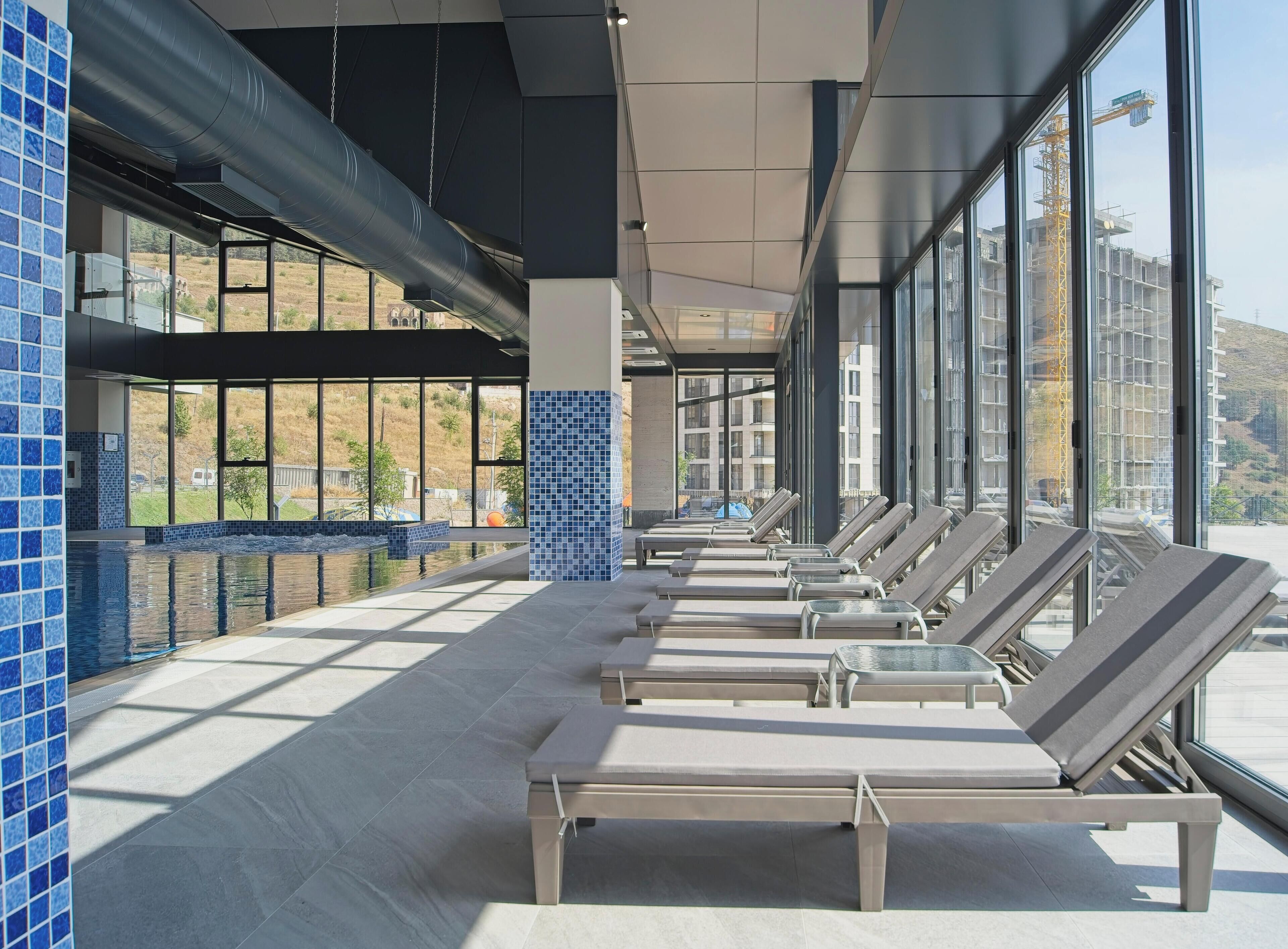 Una piscina techada, una piscina al aire libre de temporada, sombrillas