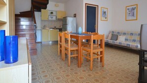 Un espacio habitable compacto con comedor, kitchenette y sofá.