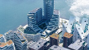 A high-rise building with a unique angular design, surrounded by other modern structures. - City Central Apartment w Modern Nordic Interiors (Aarhus)