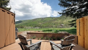 A deck with two Adirondack chairs facing a landscaped garden and a view of a hilly landscape. - Scenic Vail Escape | Walk to Shuttle, Near Trails | Newly Renovated (Vail)