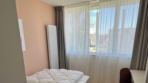 Una camera da letto con un letto, una scrivania e una sedia.